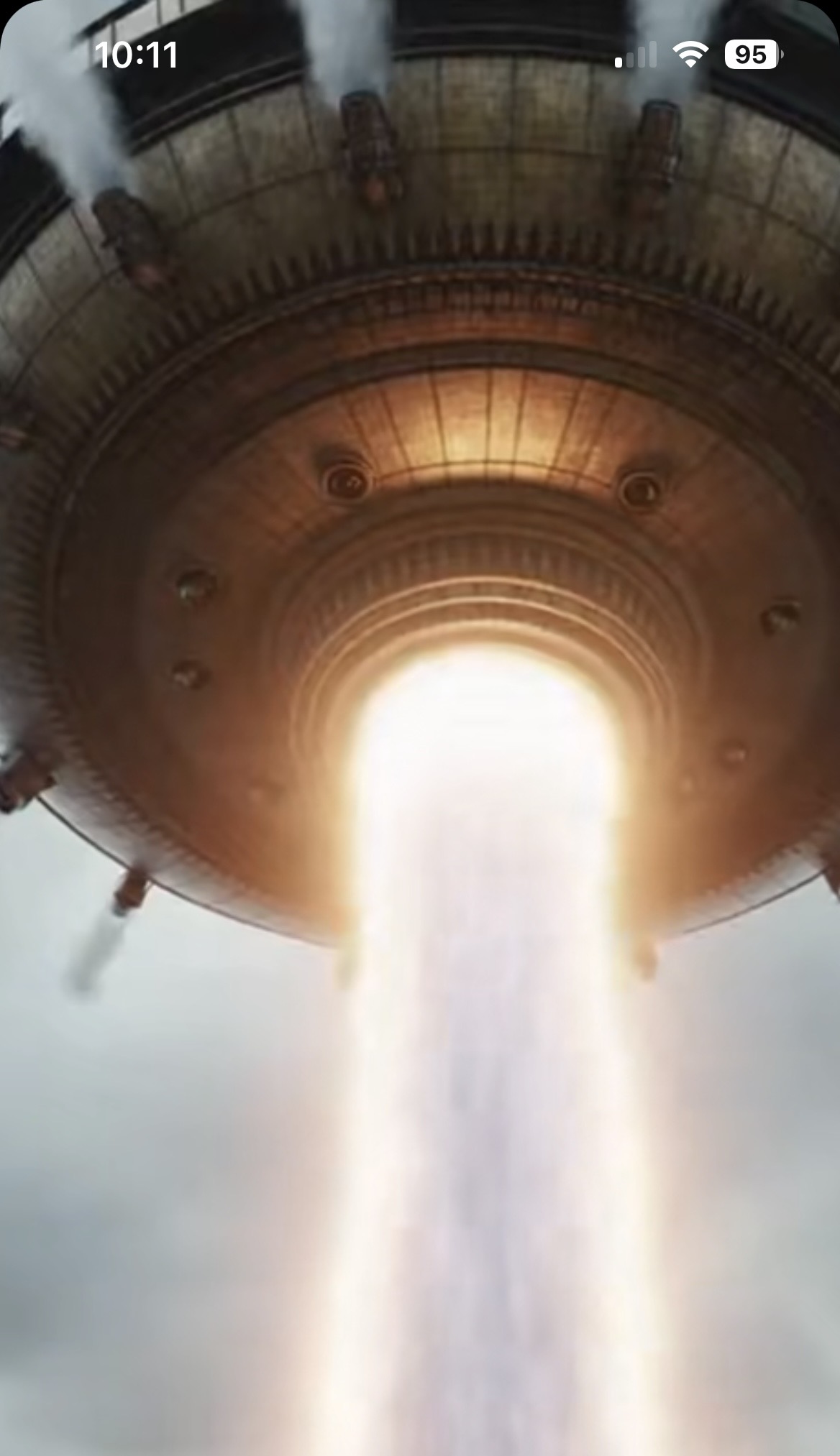 A large circular craft projecting a vertical beam of light downward.